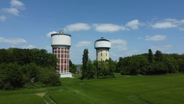 A smooth span overlooking two water towers, against a backdrop of green, cultivated fields, and trees. Water towers in Hamm, Germany.