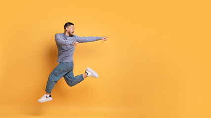 Great Offer. Asian guy jumping in air and pointing at copy space