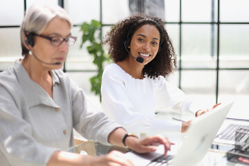 Young friendly operator woman agent with headsets working in a call centre.