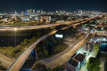 Fototapeta na wymiar Aerial view of american freeway intersection at night with fast driving cars and trucks in Miami, Florida. View from above of USA transportation infrastructure