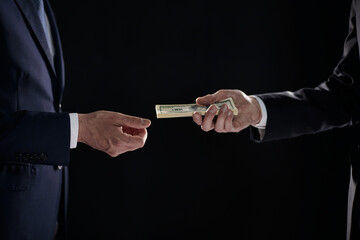 Money transfer between colleagues on a black background