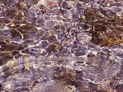 Seabed ocean floor pebbles stones underwater clear water. 