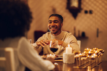 Smiling african american man having a romantic date with his girlfriend at home