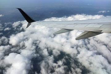 Obraz premium View through airplane window of commercial jet plane wing flying high in the sky. Air travelling concept