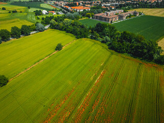 Aerial view of Poasco in Italy surrounded by fields and countryside. Milan, Lombardy Aerial photo. Top view of countryside and green fields. Country Life Concept. Aerial photography in the summer.  