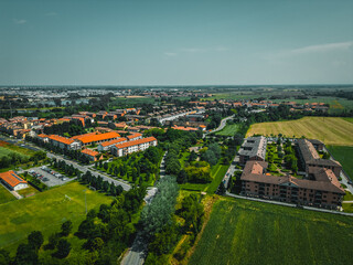 Aerial view of Poasco in Italy surrounded by fields and countryside. Milan, Lombardy Aerial photo. Top view of countryside and green fields. Country Life Concept. Aerial photography in the summer.  