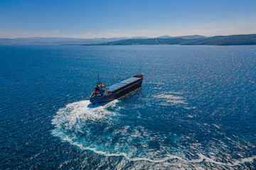 Bulk carrier ship manoeuvring in sea, Aerial view