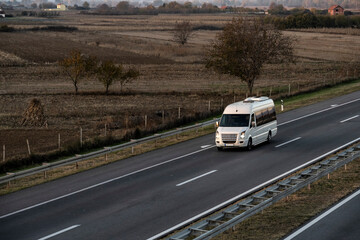 White Small modern comfortable tourist bus driving on the highway. The concept of travel and bus tourism. © Bojan