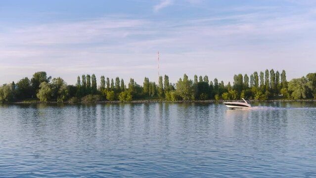 Boot f&auml;hrt auf dem Rhein.Wasser und Landschaft bei Mainz. Schnelboot in Zeitlupe.
