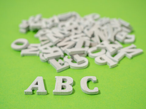 Wooden letters on a green background. Wooden letters abc concept of school and learning.