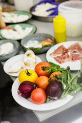 Fresh prosciutto, mozzarella, tomatoes and vegetable on the table