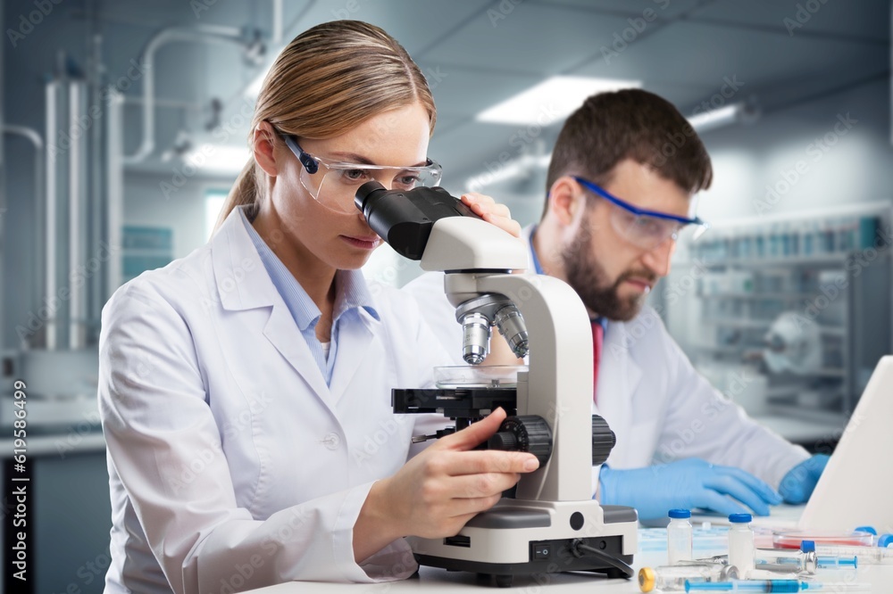 Poster professional scientist working in modern laboratory, looking in a microscope