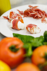 Fresh prosciutto, mozzarella, tomatoes and vegetable on the table. 
Prosciutto Wrapped Mozzarella Sticks.
Prosciutto and Mozzarella antipasti.