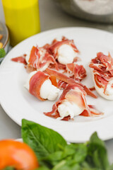 Fresh prosciutto, mozzarella, tomatoes and vegetable on the table.
Prosciutto Wrapped Mozzarella Sticks.
Prosciutto and Mozzarella antipasti.