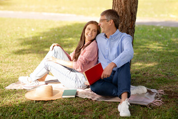 Love And Literature. Romantic Mature Spouses Reading Books And Relaxing In Park