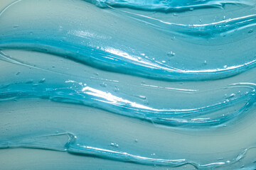 Cosmetic blue gel or lotion or hyaluronic acid transparent gel balm smudge texture background