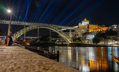 Fototapeta na wymiar dom luiz brige lighht show in Porto on the riverside of Duero river cityscape at night