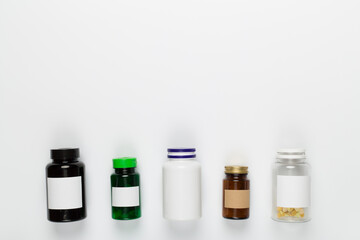 Plastic bottles with vitamins on white background, top view