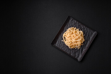 Delicious dried squid in the form of shavings with salt and spices on a ceramic plate