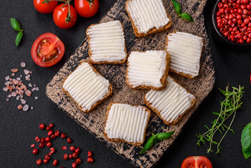 Delicious salty rectangular wheat croutons with cream cheese and tomatoes