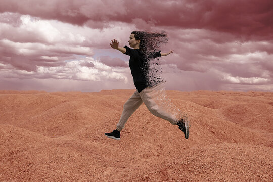 A young woman runs across Mars and disintegrates into particles. Futuristic space portrait, red earth and red picturesque sky. Image of a Landscape similar to Mars