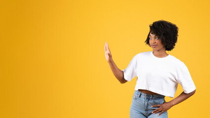 Dissatisfied millennial black woman in casual making stop gesture with hand