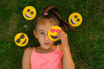 A surprised beautiful sweet girl closes her eye with a small emoji with hearts. The holiday is the...