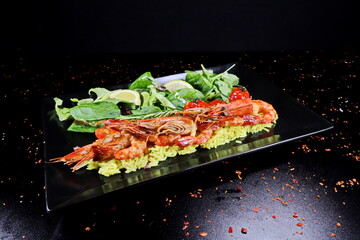 Shrimps with rice and vegetables on a black background in a restaurant - 619607413