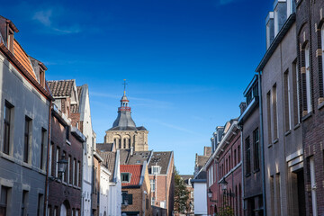 Fototapeta na wymiar Sint Matthiaskerk church in a typical street in the city center of Maastricht, old street with residential buildings. Church of Saint Matthias is a Roman catholic church of the Netherlands.