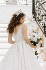 a girl in the image of a bride in a wedding dress, with open shoulders, with curly long brown hair,...