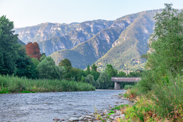 Mountain landscape with a bridge over the river in the summer . Brenta river and Alps in Bassano del Grappa in Italy