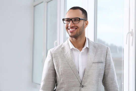 Smiling young businessman in his modern office