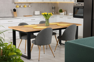 Spring atmosphere. Stylish kitchen interior with comfortable furniture and bouquet of beautiful yellow tulips