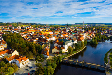Fototapeta na wymiar Scenic view from drone of historic center of small Czech town of Pisek on banks of Otava river on autumn day
