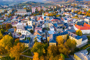 Panoramic aerial view of autumn landscape of Czech town of Sumperk with Church of Saint John Baptist and Town hall at sunrise, Olomouc Region - obrazy, fototapety, plakaty