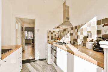 a kitchen with white cabinets and wood counter tops in the center of the image is an open door leading to another room