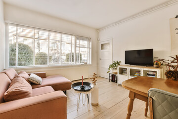 a living room with a couch, coffee table, and television on the wall in the room is bright white