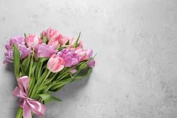 Beautiful bouquet of colorful tulip flowers on light gray table, top view. Space for text