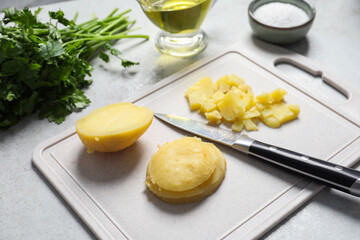 Cut boiled potatoes and ingredients on white table, closeup. Cooking vinaigrette salad
