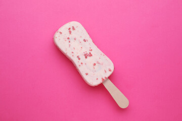 Delicious glazed ice cream bar on pink background, top view