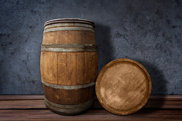 Obraz premium Wooden barrels on surface near dark textured wall
