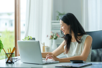 A businesswoman working on new project with laptop computer in modern office.