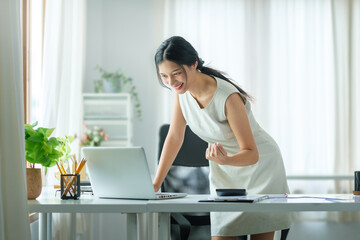 Happy businesswoman reading good news on computer laptop and celebrating her success. Successful work concept.