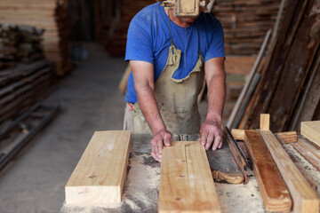 Timeless Craftsmanship: Man Cutting Wood on a Vintage Band Saw in a Woodworking Shop