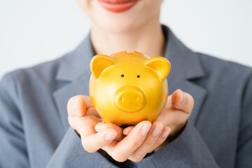 豚の貯金箱を持っている若い女性　ビジネスイメージ