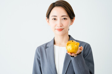 豚の貯金箱を持っている若い女性　ビジネスイメージ