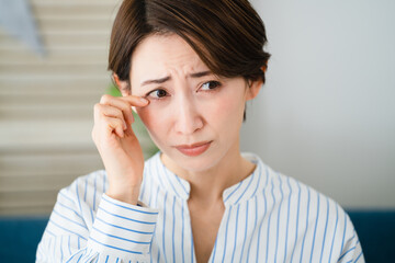 目を掻く若い女性　花粉症イメージ	
