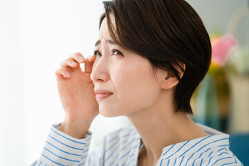 目を掻く若い女性　花粉症イメージ	
