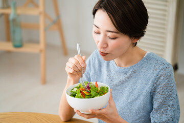 サラダを食べる若い女性　飲食イメージ