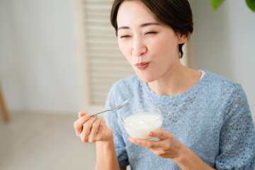 ヨーグルトを食べる若い女性　飲食イメージ	
